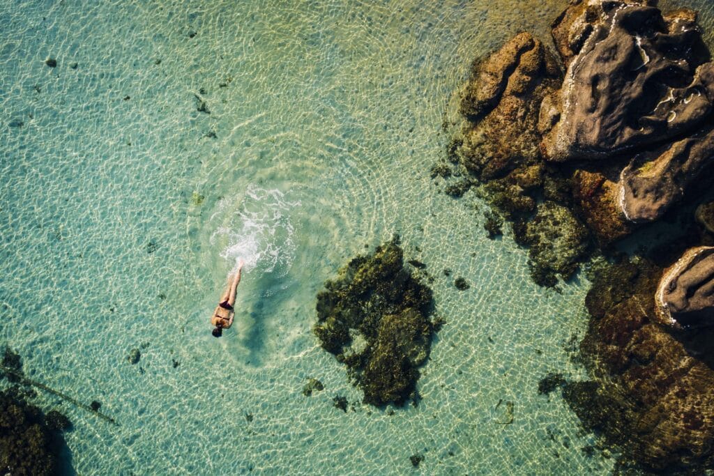 Swimmer in the clear, calm water of a quiet Mediterranean cove