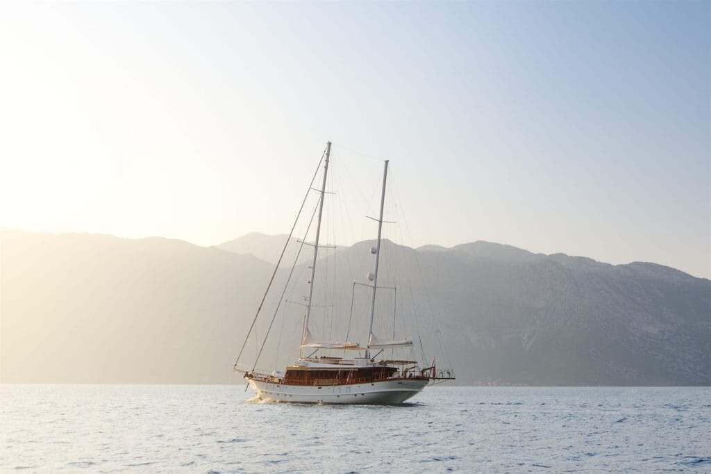 Small sailing ship anchored in a calm bay at first light