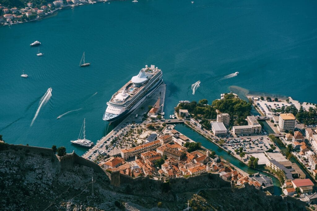 Cruise ship docked beside the old town of Kotor seen from above