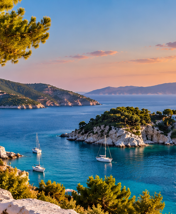 Panoramic view of the Sporades and Cyclades with turquoise Aegean waters, whitewashed Greek island houses and pine-covered coastline at sunset.